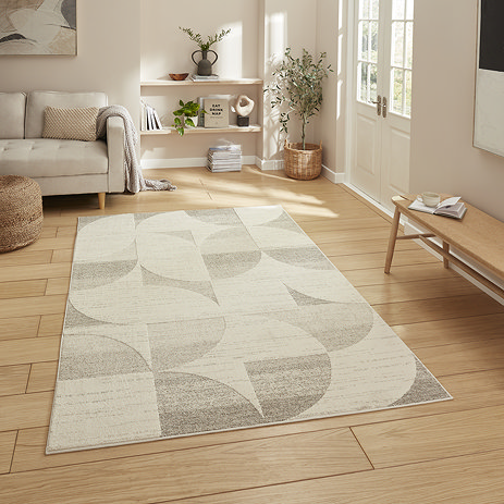 image of beige and cream rectangle rug with geometric patterns on light wooden floor of modern loft apartment