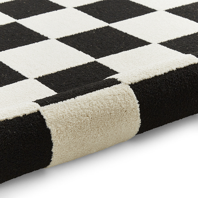image of black and white checkered rug rolled up at the end