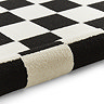 image of black and white checkered rug rolled up at the end
