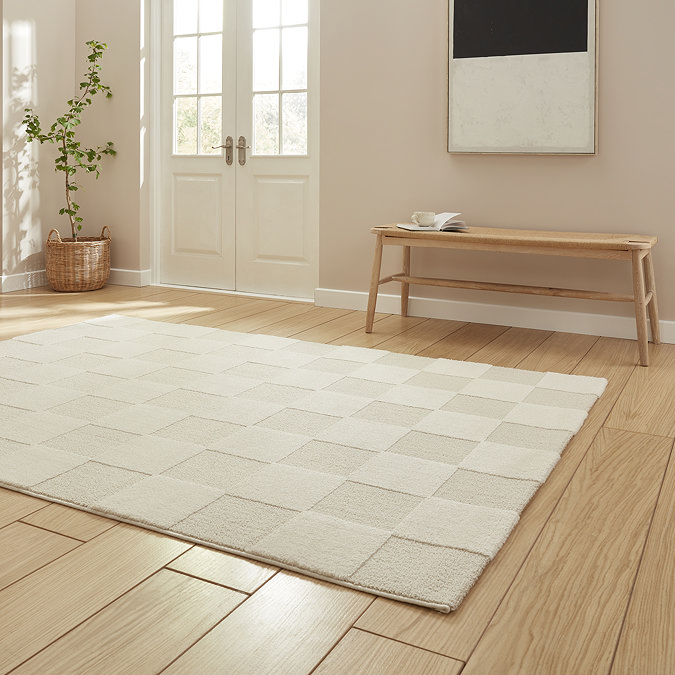 angled image of cream checkered rectangle rug on light wooden flooring