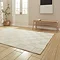angled image of cream checkered rectangle rug on light wooden flooring