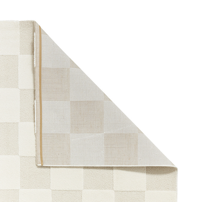 image of cream checkered rug folded over at the corner to show floor-facing material underneath