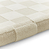 image of cream checkered rug rolled up at end