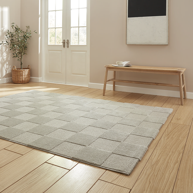 angled image of silver checkered rug on light wooden flooring