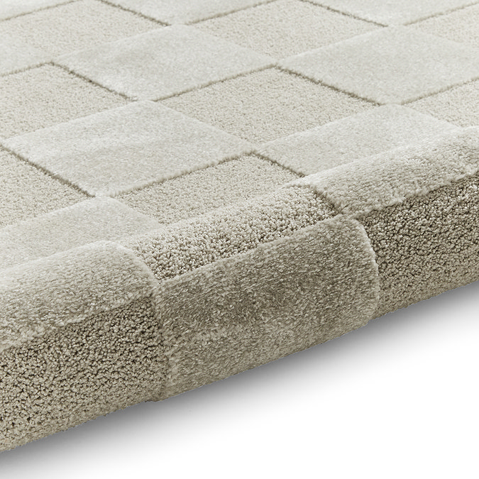 image of silver checkered rug rolled up at the end