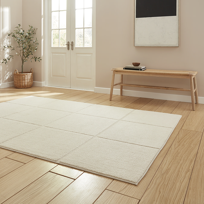 angled image of cream rug with modern line detailing on light wooden floor