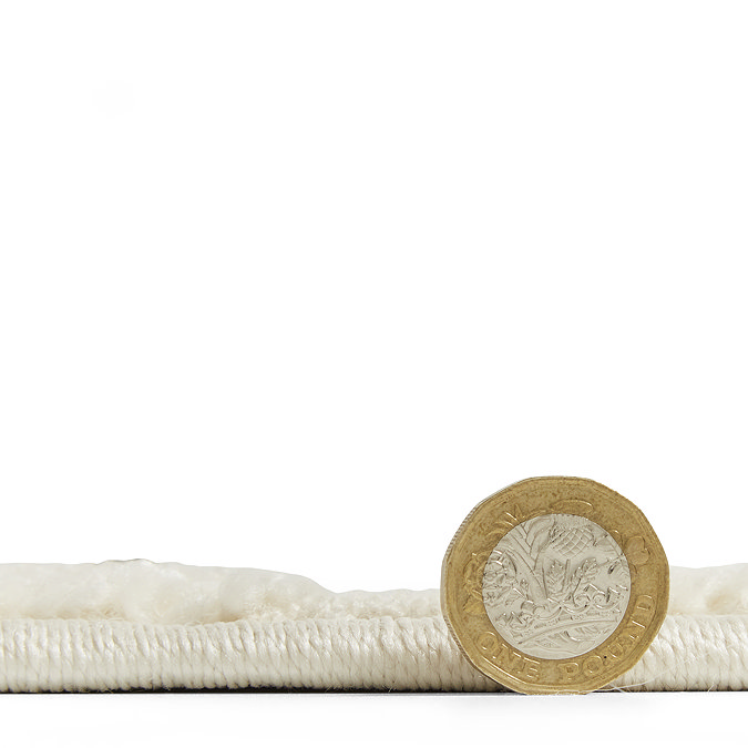 side on image of rug flat with pound coin stood up next to it to show rug as half the coin's height