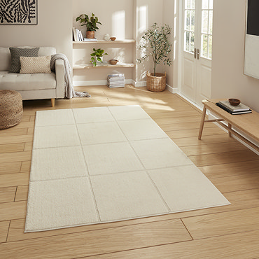 angled image of cream rug with modern line detailing on light wooden floor