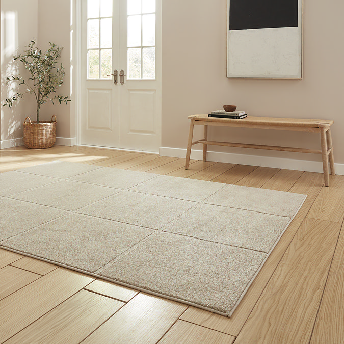 angled image of light brown rug with line detail on light wooden flooring