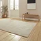 angled image of light brown rug with line detail on light wooden flooring
