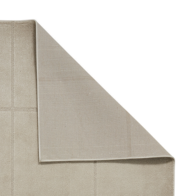 image of light brown rug folded over in the corner to show floor-facing  material