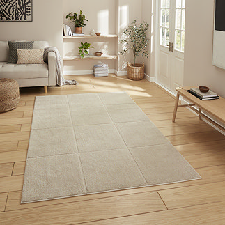 image of mink brown rectangle rug with line detail on light wooden flooring in a modern loft apartment
