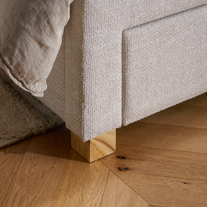 close up on light grey velvet fabric of grey bed with light wood legs