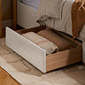 close up image on side drawer of velvet bed pulled out with duvets inside