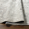 close up image of dusty sage green and grey vintage rug ruched up to suggest its thinness