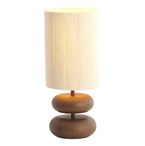 image cut out on white background of brown wood-effect lamp with cylindrical linen shade, lamp turned on to emit warm glow