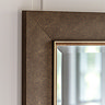 close up on corner of bronze rectangular wall mirror