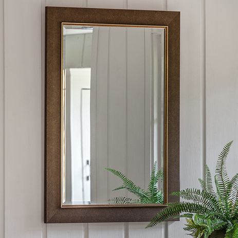 image of rectangular wall mirror in bronze finish on cream wall