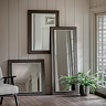 wide image of collection of mirrors on wall