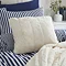 cream faux fur cushion on blue bedding
