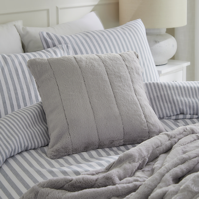 grey faux fur square cushion on light blue bedding