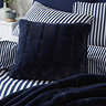 navy blue square faux fur cushion on blue striped bedding