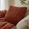 Rust coloured faux fur cushion on sofa