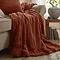 Empress throw in rust draped over a sofa image 1