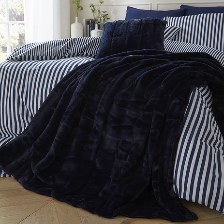 Empress throw navy draped over a bed image 1