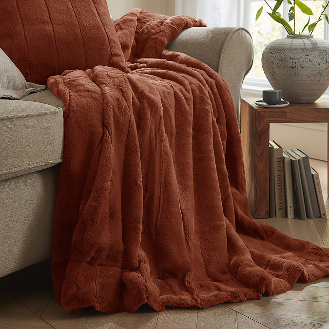 Empress throw in rust draped over a sofa image 1