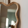close up image of wavy edge of light oak leaner mirror