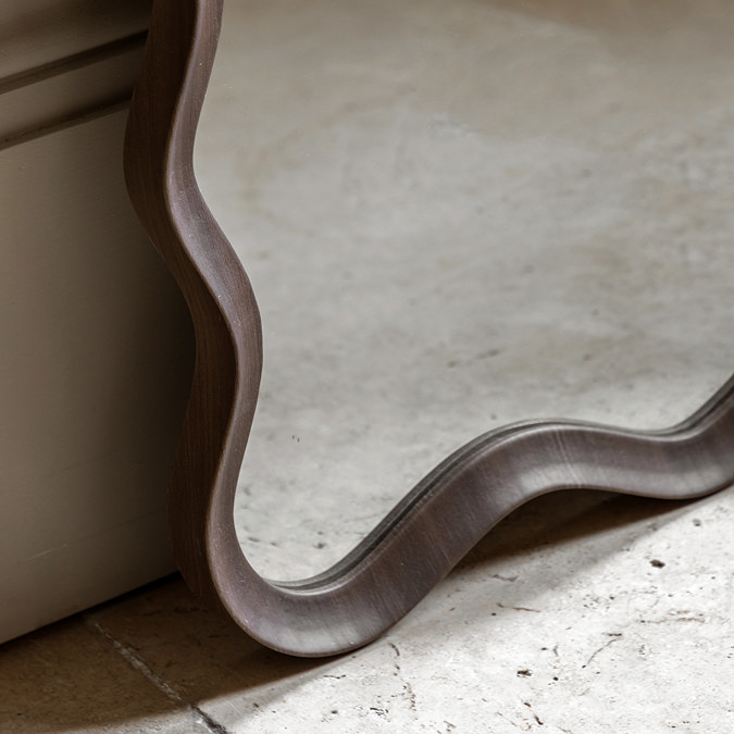 close up image of walnut wiggle shaped frame of floor mirror