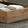 close up on oak frame of ottoman bed with storage compartment, clothes folded up inside