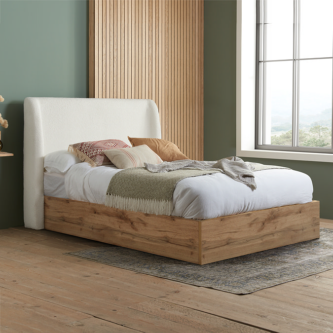 oak ottoman bedframe with white boucle headboard, dressed in sheets and decorated with natural coloured cushions and throws
