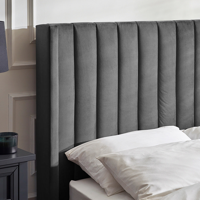 close up image of panelled fabric headboard of dark grey bed