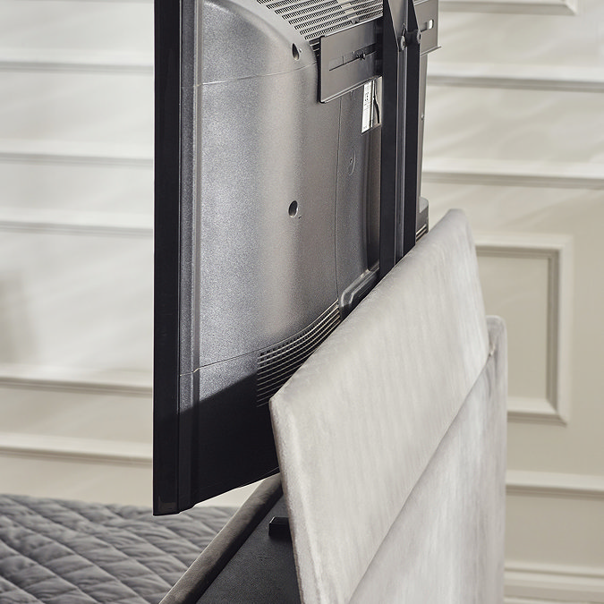 close up image of tv coming out of footboard of light grey ottoman bed