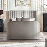 front on image of light grey fabric ottoman bed with rounded footboard and panelled headboard