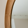 close up image of woodgrain of oval mirror frame
