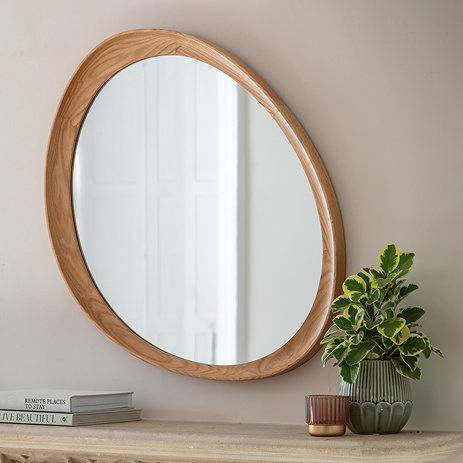 image of oak pebble shaped mirror above mantlepiece with small potted plant