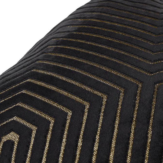 close up of gold geometric piped detailing on black cushion