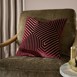 45x45cm burgundy red cushion with geometric detail, sat on dark khaki chair