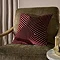 45x45cm burgundy red cushion with geometric detail, sat on dark khaki chair