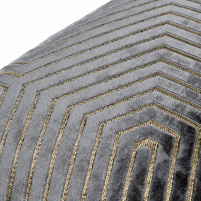 close up of textured grey cushion with gold geometric detailing.