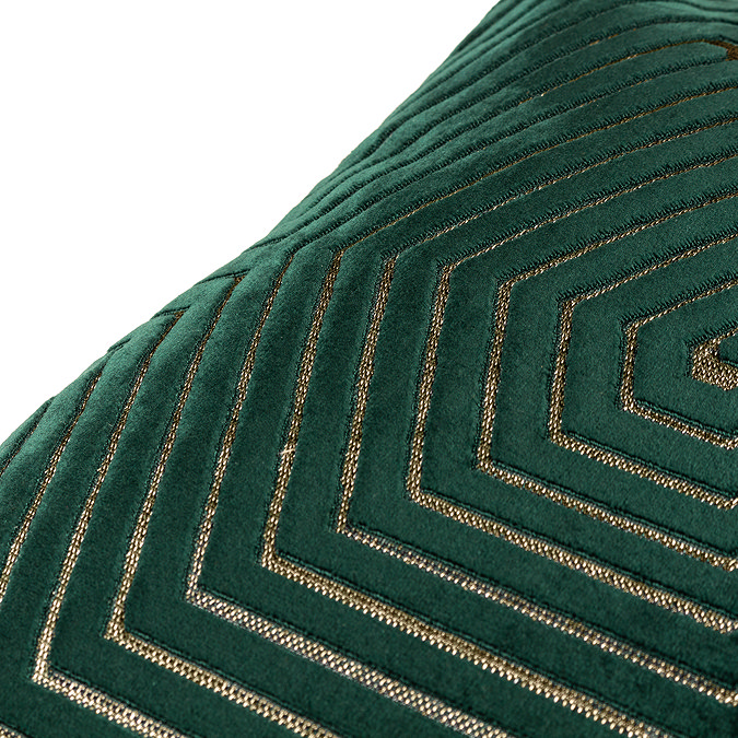 close up of pattern of emerald green velvet cushion with gold geometric detailing.