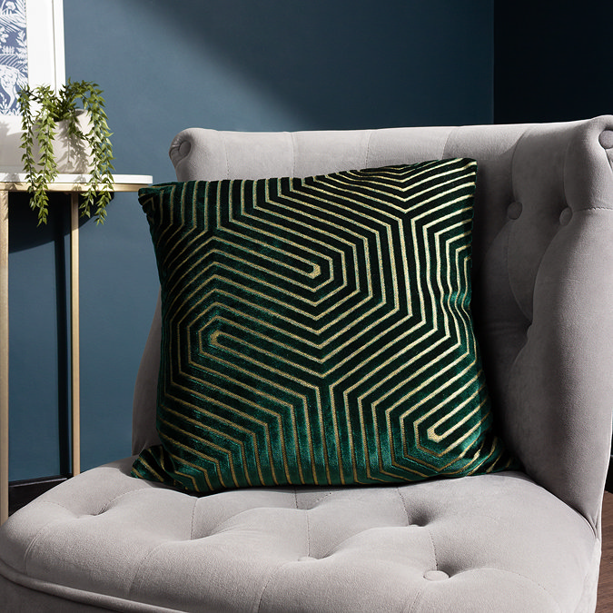 45x45cm emerald green cushion with geometric detailing, sat on grey chair