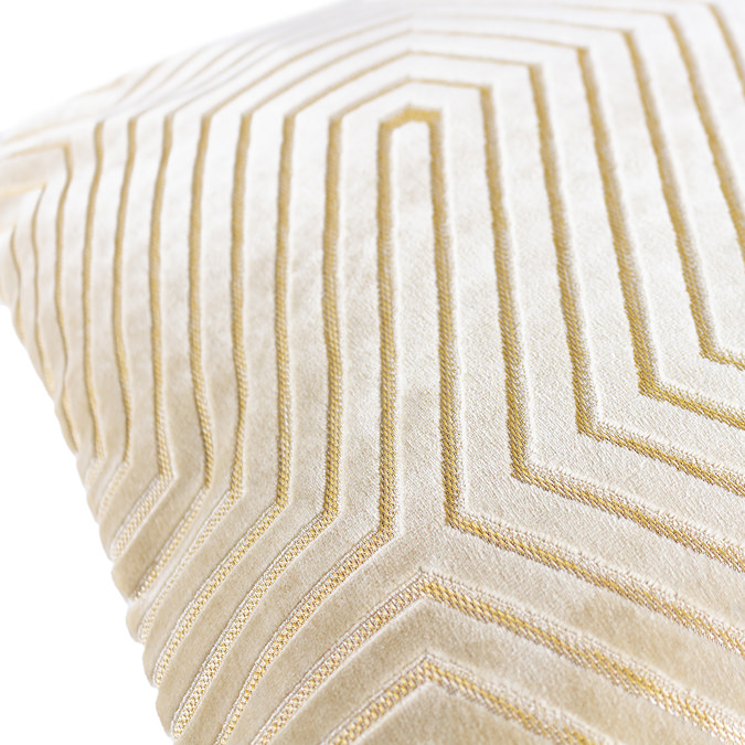 close up image of ivory velvet cushion with gold geometric detailing.