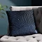 45x45cm navy blue square cushion with geometric detailing sat on grey armchair