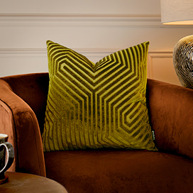 45x45cm olive green cushion with geometric detailing, sat on rust coloured armchair