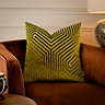 45x45cm olive green cushion with geometric detailing, sat on rust coloured armchair