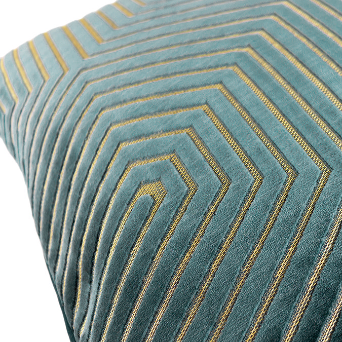 close up on pattern of teal green velvet cushion with cut geometric detail